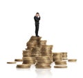 Businessman in black suit standing on heap of glittering golden coins isolated white background Royalty Free Stock Photo