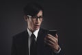 Businessman in black suit worried looking at smart phone