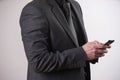 Businessman in black, trendy, modern and stylish suit using smartphone Royalty Free Stock Photo