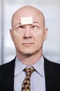 Businessman with a blank note on his forehead Royalty Free Stock Photo