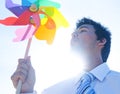 Businessman blowing pinwheel relaxation concept