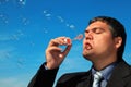 Businessman blows soap bubbles against sky Royalty Free Stock Photo