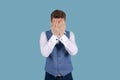 Businessman in blue suit with sad expression, covering his face with his hands Royalty Free Stock Photo