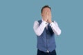 Businessman in blue suit with sad expression, covering his face with his hands Royalty Free Stock Photo