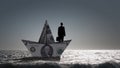 Businessman in boat made of dollar banknote