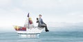 Businessman in boat made of paper