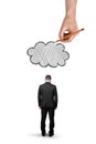 Businessman with bowed head standing and big hand above that draws cloud, isolated on white background