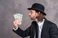 Businessman with bowler hat in black suit showing money Royalty Free Stock Photo