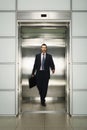 Businessman With Briefcase Coming Out From Elevator Royalty Free Stock Photo