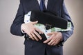 Businessman with a briefcase full of money in the hands of