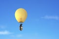 Businessman in brightly yellow lamp hot air balloon flying Royalty Free Stock Photo