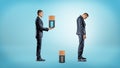 A businessman brings a large fully charged battery to replace a depleted one from inside a very tired businessman. Royalty Free Stock Photo