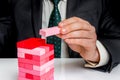 Businessman builds big tower with jenga bricks Royalty Free Stock Photo