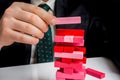 Businessman builds big tower with jenga bricks Royalty Free Stock Photo