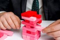 Businessman builds big tower with jenga bricks Royalty Free Stock Photo