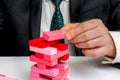 Businessman builds big tower with jenga bricks Royalty Free Stock Photo