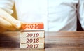 Businessman builds wooden blocks 2020. The concept of the beginning of the new year. New goals. Next decade. Trends and changes in Royalty Free Stock Photo