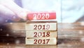 Businessman builds wooden blocks 2020. The concept of the beginning of the new year. New goals. Next decade. Trends and changes in