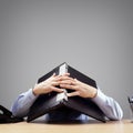 Businessman burying his head under a laptop computer asking for help Royalty Free Stock Photo