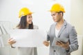 Businessman and businesswoman with blueprint and helmets discuss Royalty Free Stock Photo
