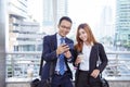 Businessman Businesswoman drinking coffee in town using smartphone outside office modern city. Hands holding take away coffee cup Royalty Free Stock Photo