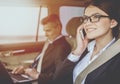 Businessman and Businesswoman with Gadgets in Car. Royalty Free Stock Photo