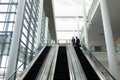 Businessman and businesswoman interacting with each other while moving down on escalator Royalty Free Stock Photo