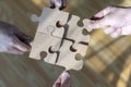 Businessman and businesswoman, joining four blank matching puzzle pieces. Businessmen working together to build a puzzle Royalty Free Stock Photo