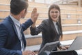 Businessman and businesswoman looking at each other and doing high five hands celebrate after sales target completed