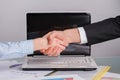 Businessman and businesswoman shaking hands over the desk. Royalty Free Stock Photo