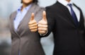 Businessman and businesswoman showing thumbs up