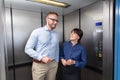 Businessman And Businesswoman Talking In Elevator Royalty Free Stock Photo