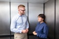 Businessman And Businesswoman Talking In Elevator Royalty Free Stock Photo