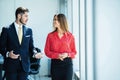 Businessman and businesswoman talking while walking in modern office Royalty Free Stock Photo