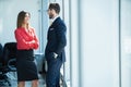 Businessman and businesswoman talking while walking in modern office Royalty Free Stock Photo