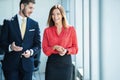 Businessman and businesswoman talking while walking in modern office Royalty Free Stock Photo