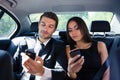 Businessman and businesswoman using smartphone in car Royalty Free Stock Photo