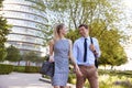 Businessman And Businesswoman Walk to Work Through City Park