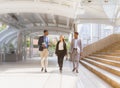 businessman and businesswoman walking with happiness outside building in city with copy space. black man in grey suit, executive Royalty Free Stock Photo