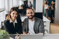 Businessman and businesswoman working with laptop at modern office