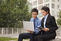 Businessman and businesswoman working together outdoors on the laptop Royalty Free Stock Photo