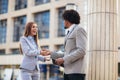 Businessman and businesswomen shaking hands outside office Royalty Free Stock Photo
