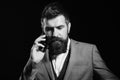 Businessman with busy face isolated on black background. Man with long beard holds mobile phone. Business and phone talk Royalty Free Stock Photo