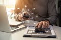 Businessman calculates financials with graph paper on the laptop computer, cell phone on the cost.