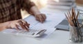 Businessman calculates financials with graph paper on the table on the cost of home office in the evening. Royalty Free Stock Photo