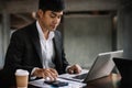 Businessman calculates financials with graph paper on the table on the cost of home office in the evening Royalty Free Stock Photo