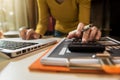 Women calculates financials with graph paper on the table on the cost of home office.