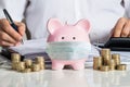 Piggybank With Face Mask Near Accountant Royalty Free Stock Photo