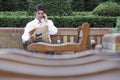 Businessman On Call While Reading Newspaper In Park Royalty Free Stock Photo