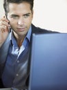 Businessman On Call While Using Laptop